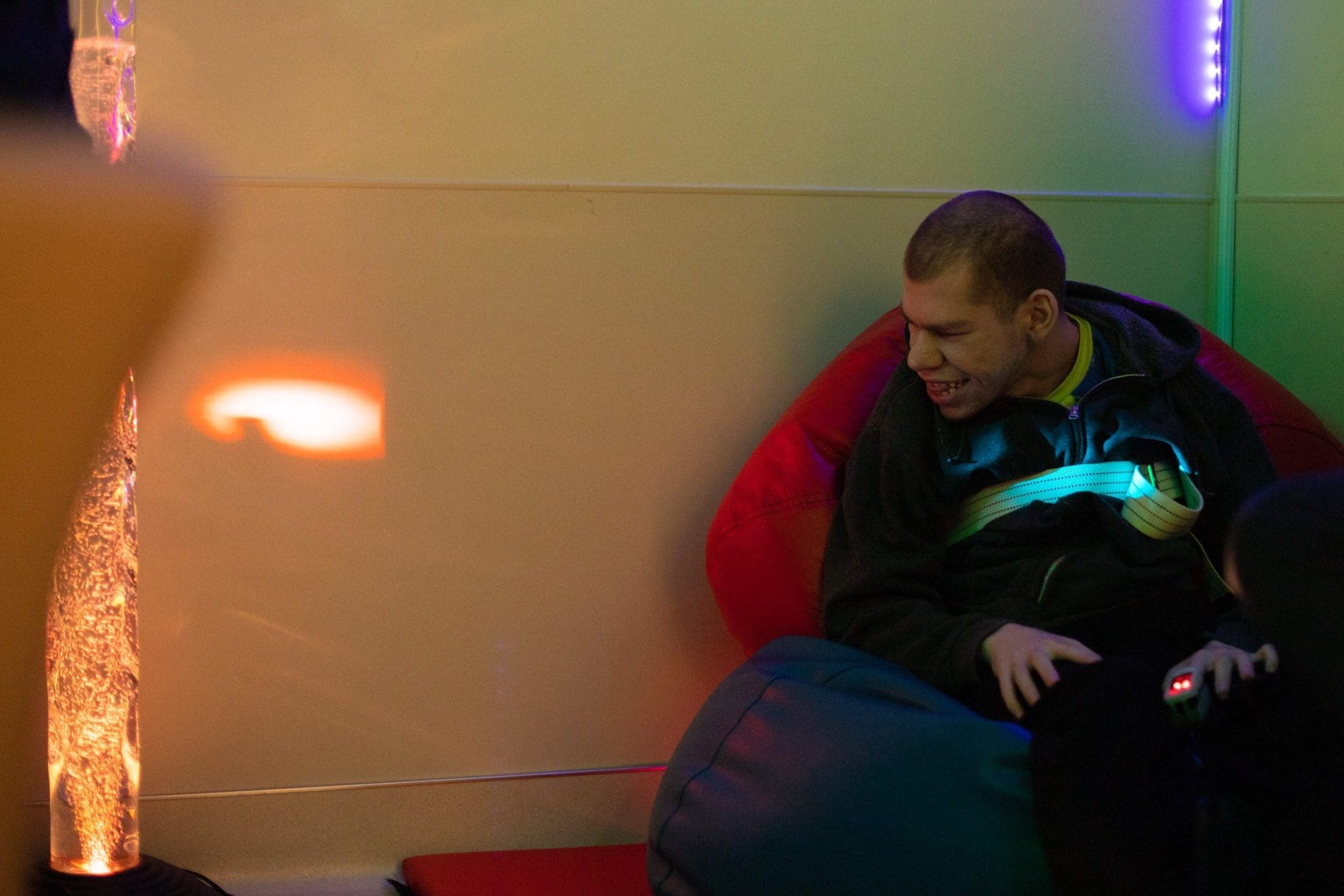 A young man with an intellectual and developmental disability receives a stress free medical exam while visiting our clinic. He sits in a bean bag chair and enjoys the calm atmosphere while having his vitals taken.
